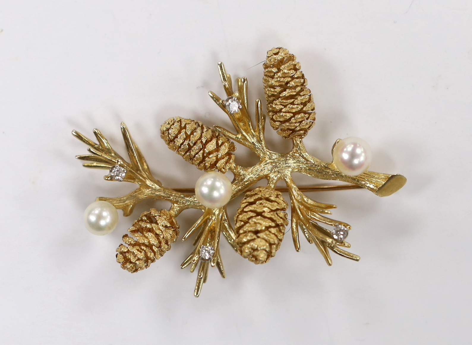 An American yellow metal, four stone diamond and three stone culture pearl set 'pine tree sprig' brooch, 56mm, gross weight 21.9 grams.